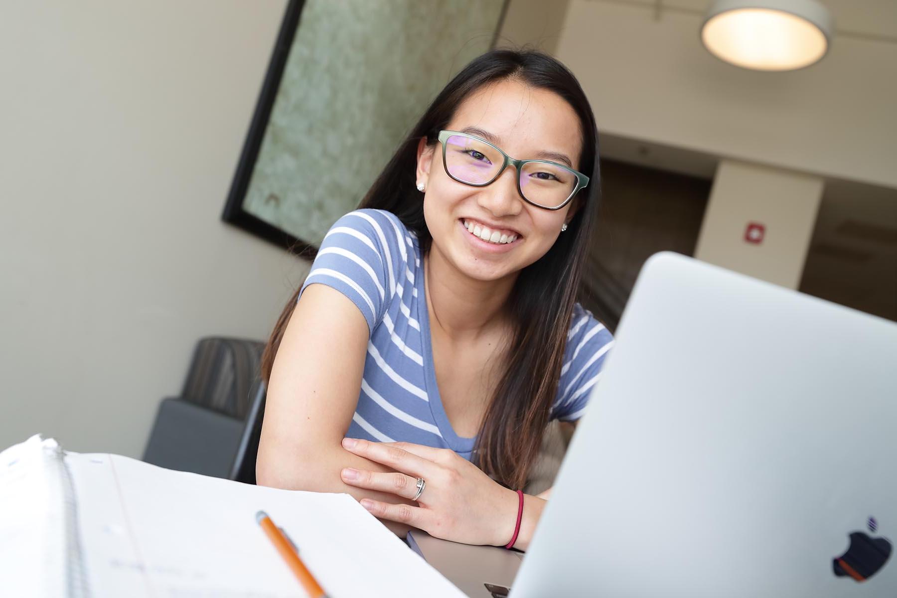 student with laptop smiling